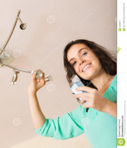 girl-changing-light-bulb-smiling-her-home-48236977